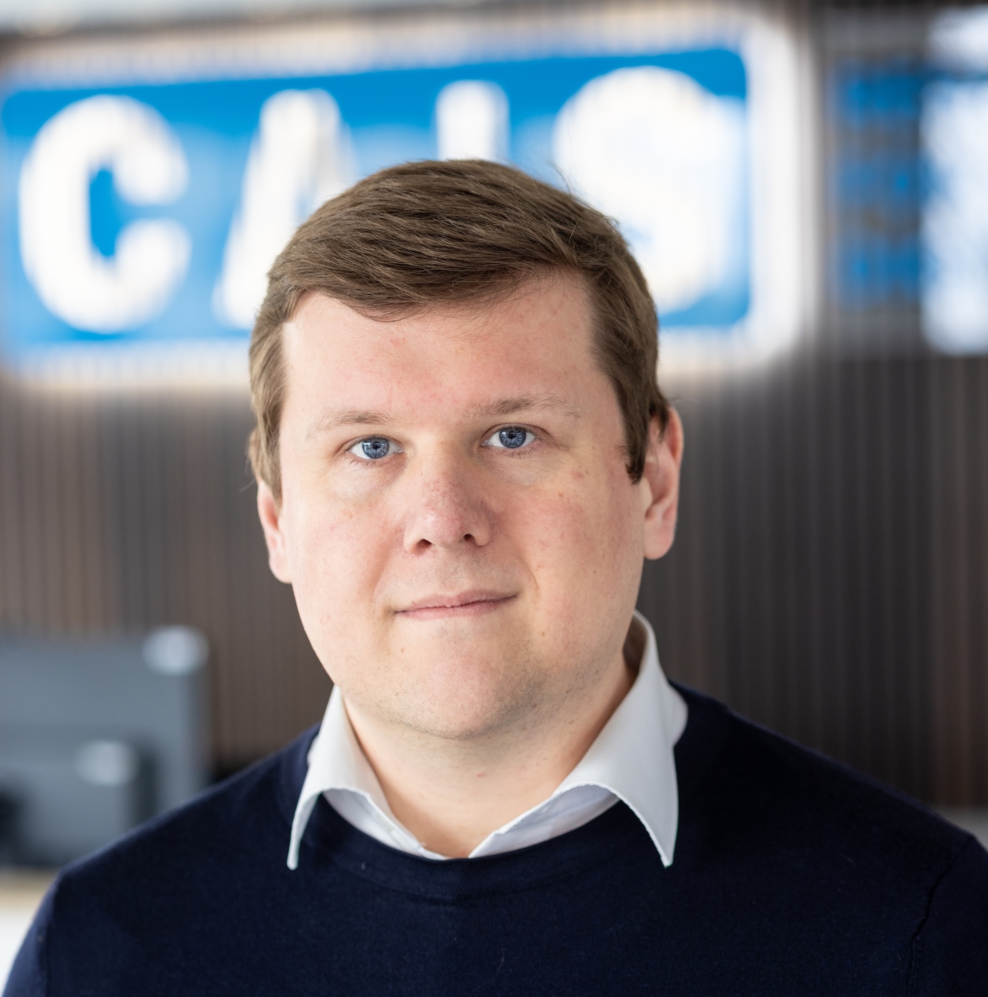 The photo shows Professor Hendrik Heuer. He is a man with a friendly expression, smiling at the camera. He has short, light blonde hair with a side part and is dressed in professional attire, including a dark blue suit and a white shirt.